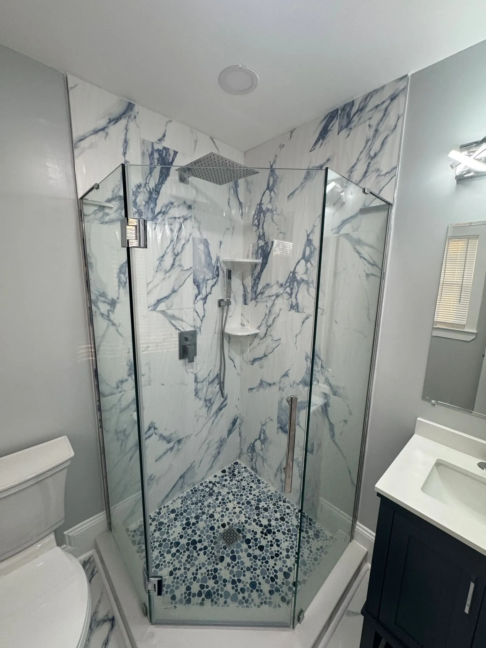 Corner shower beside a navy vanity